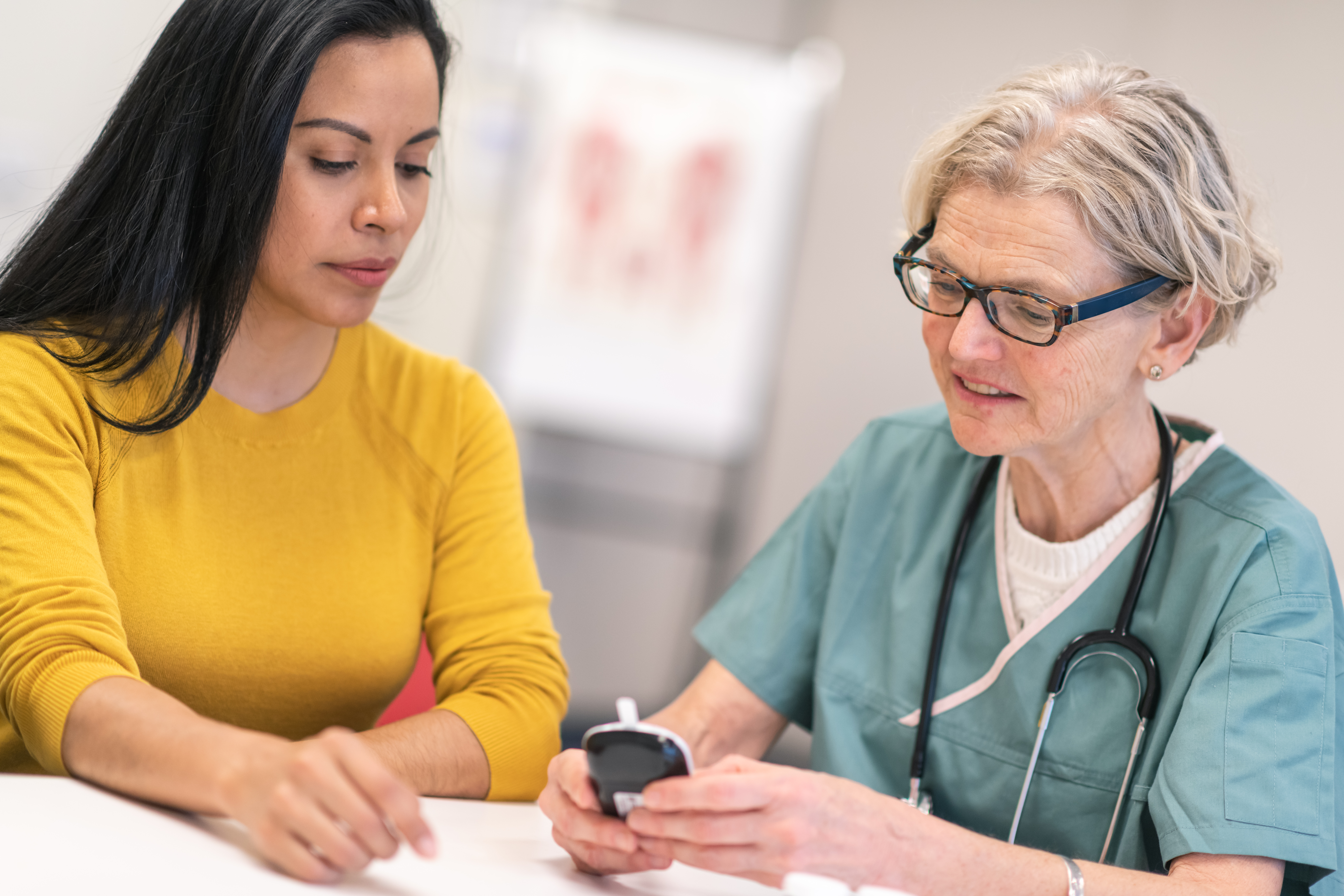 Latina woman in medical consultation with mature female doctor Latina woman in medical consultation with mature female doctor
