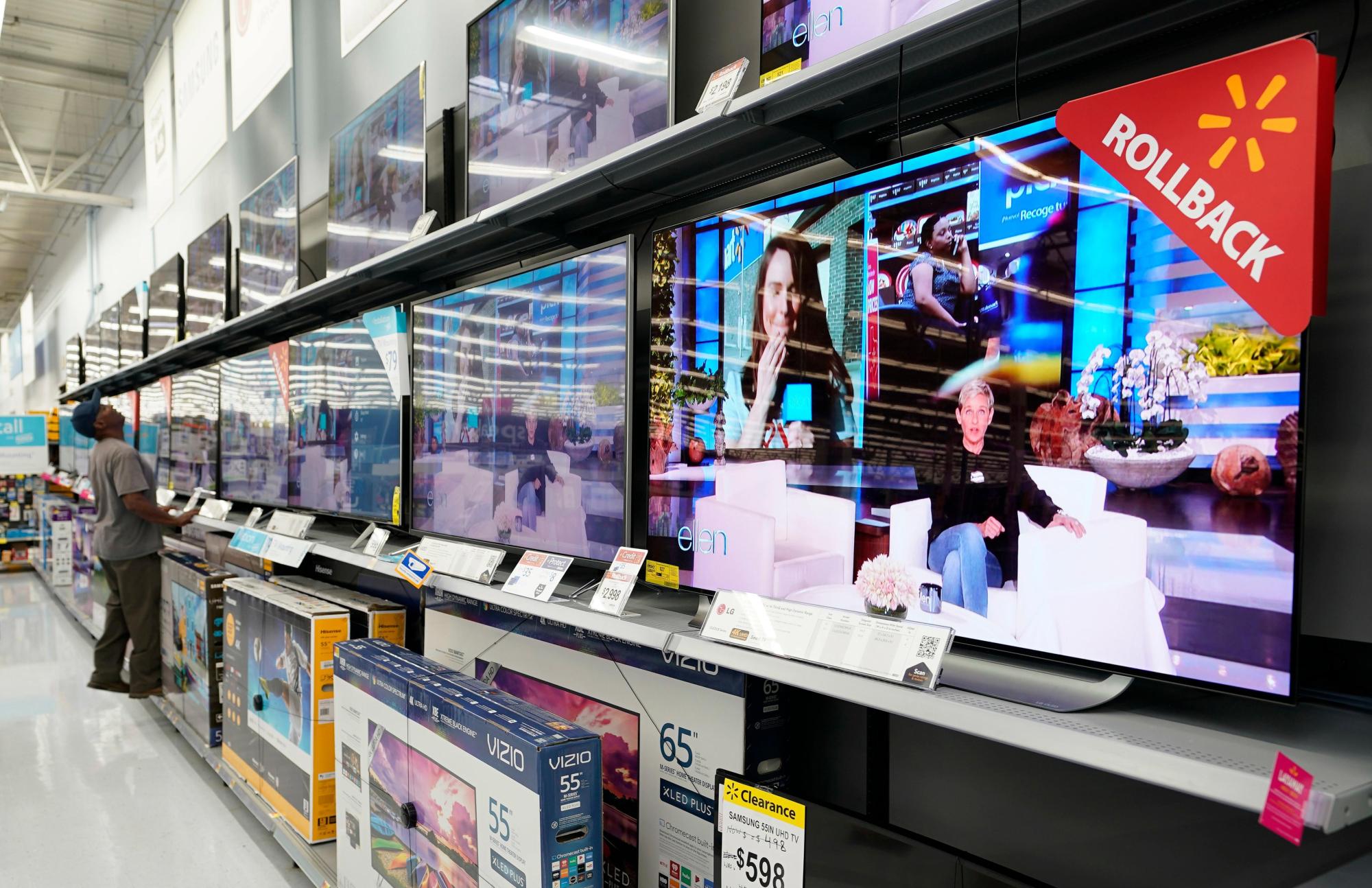 FILE – In this Nov. 9, 2018, file photo shoppers look at televisions at a Walmart Supercenter in Houston. (AP Photo/David J. Phillip, File)
