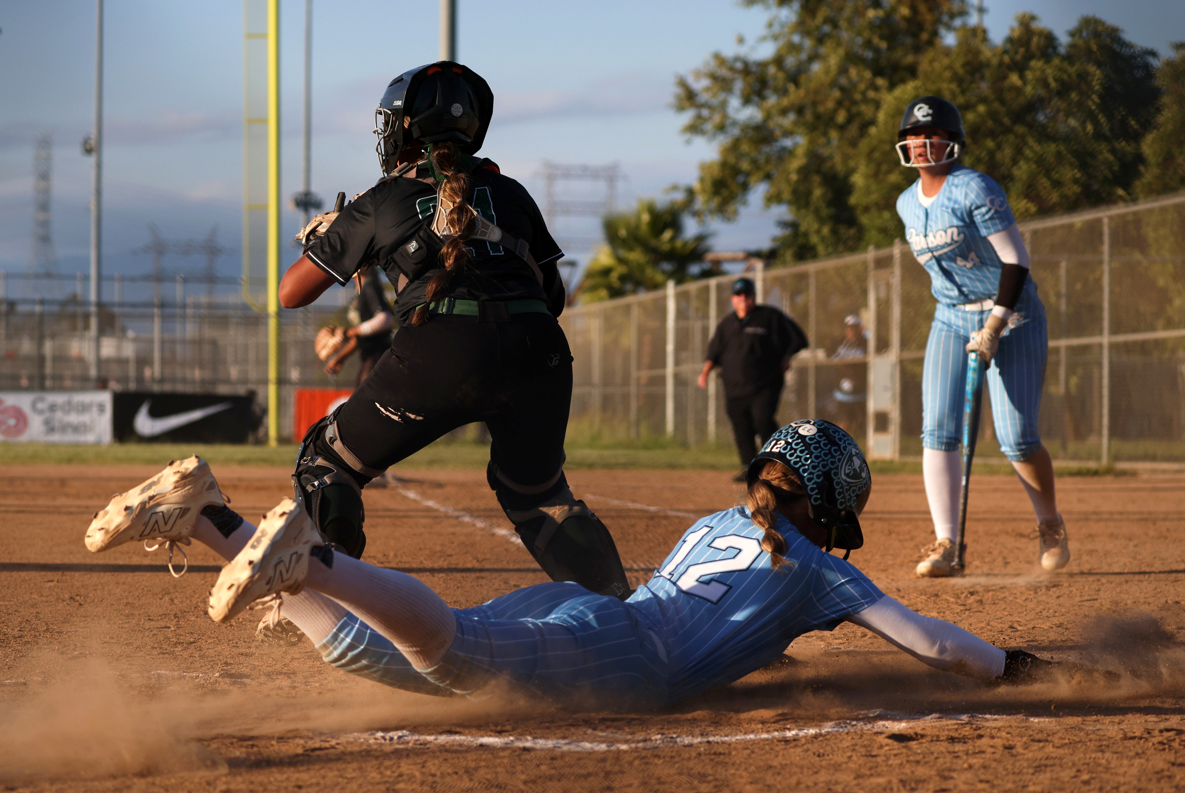 Carsonâs Ruby Grajeda (12) slides into home to score a...