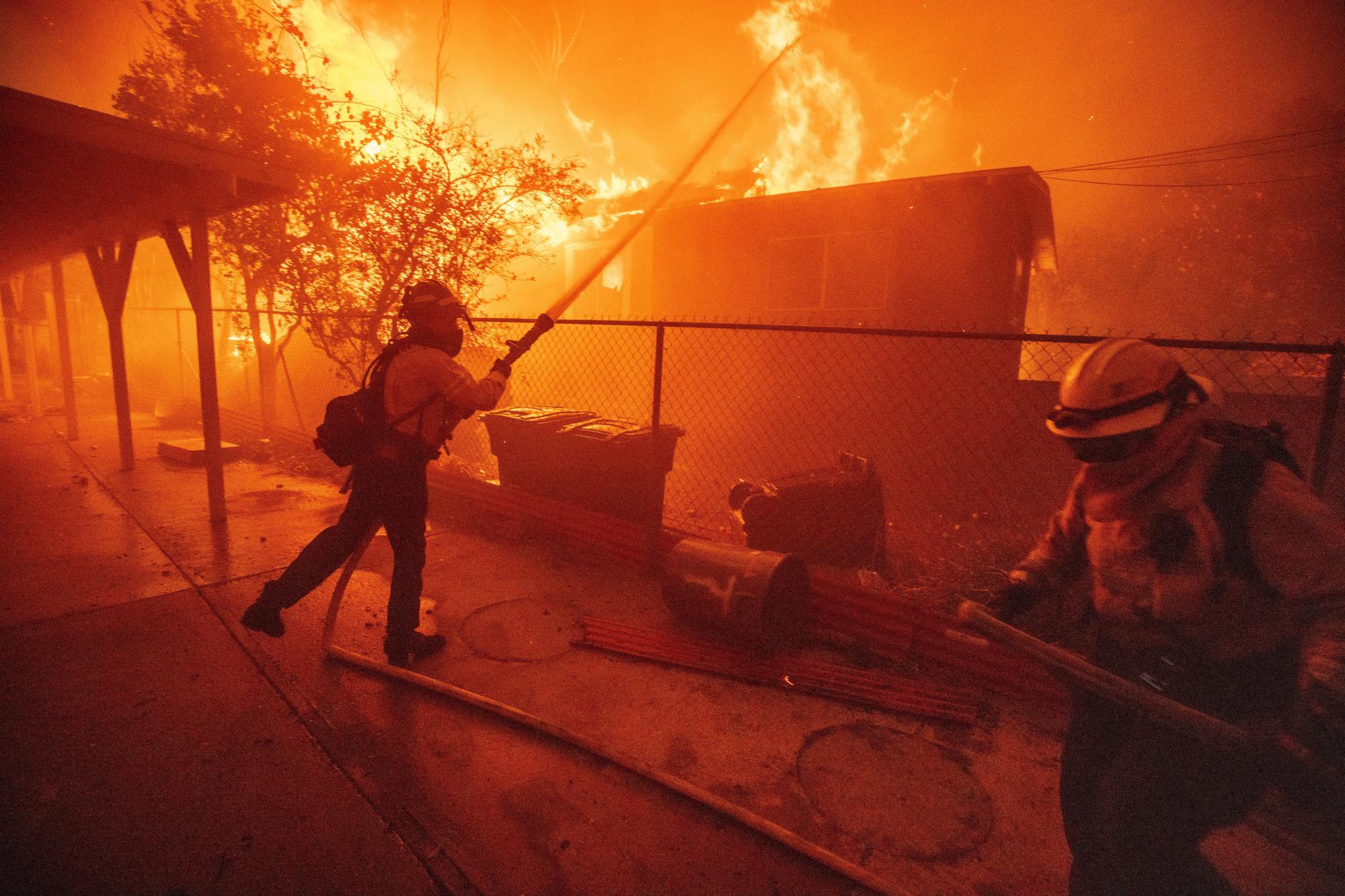 Firefighters try to protect a structure as the Eaton fire advances, Jan. 8, 2025 in Altadena, Calif. (AP Photo/Ethan Swope)
